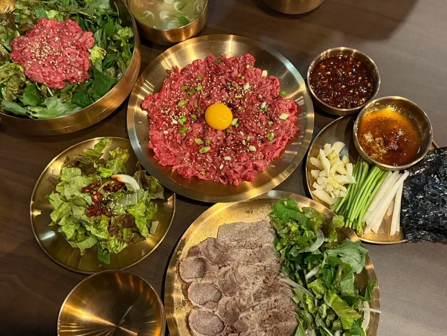 Full spread of yukhoe, suyuk and yukhoe bibimbap on the table