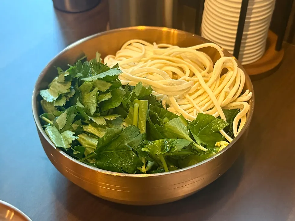 Gopchang hot pot with thin noodles and vegetables served separately