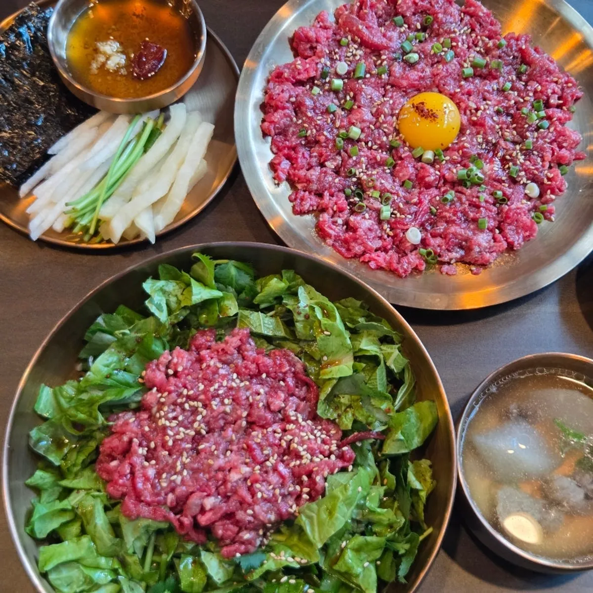 Lunch spread with yukhoe and yukhoe bibimbap in brass bowls