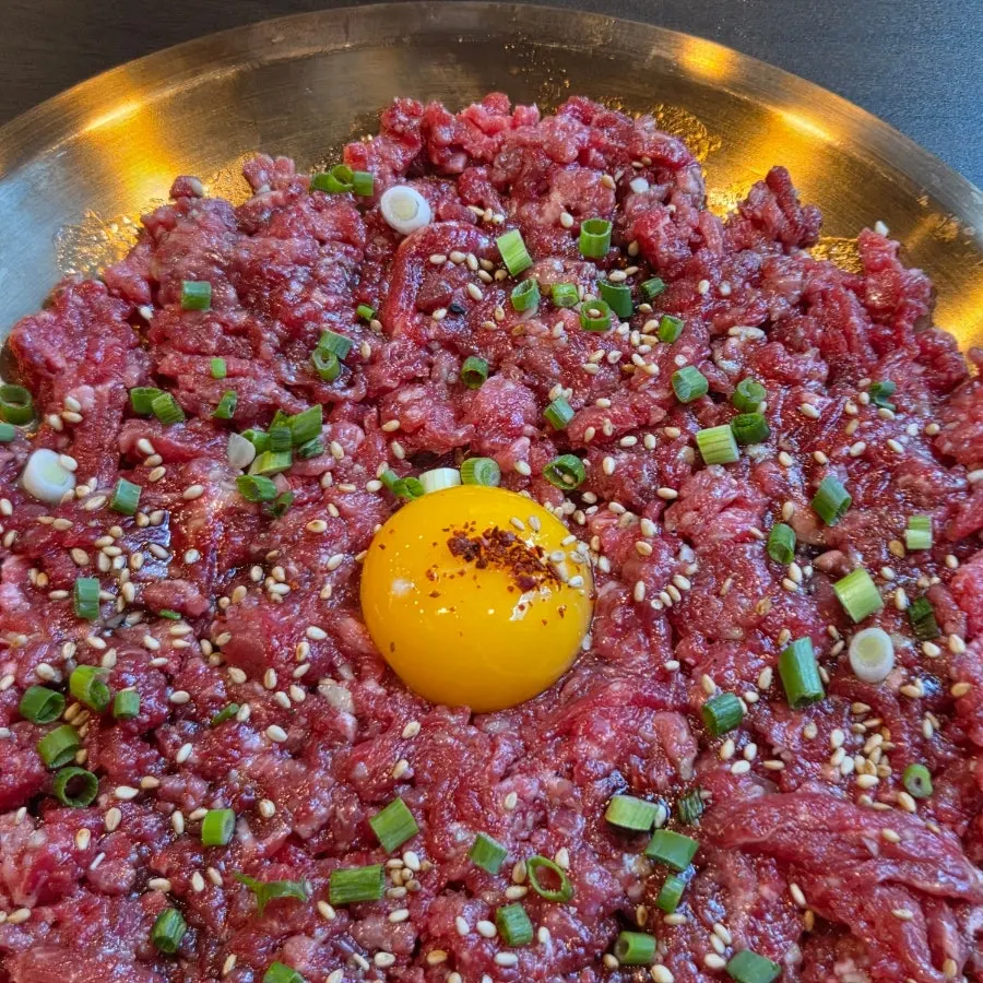 A plate of Yukhwang yukhoe topped with egg yolk