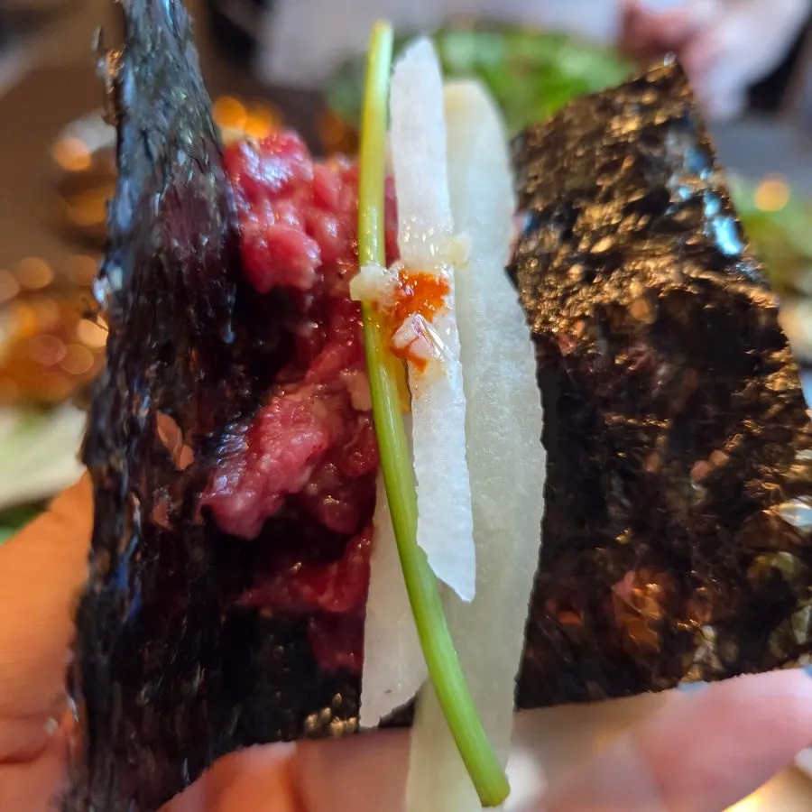 Close-up of yukhoe dipped in sauce