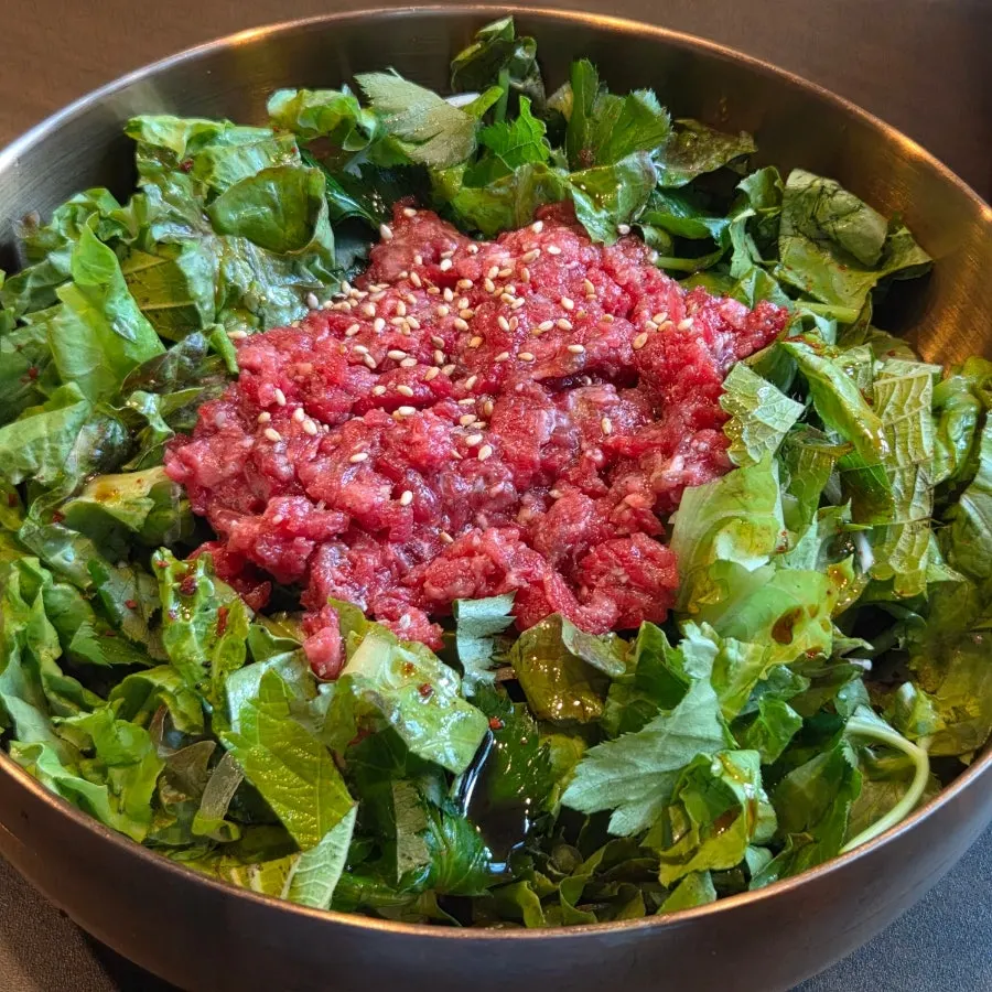 Yukhoe bibimbap topped with vegetables and yukhoe