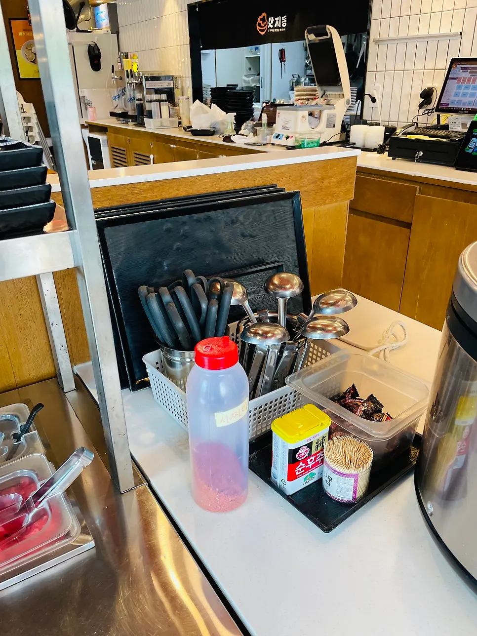 Sauces, tongs and aprons at the self-serve bar