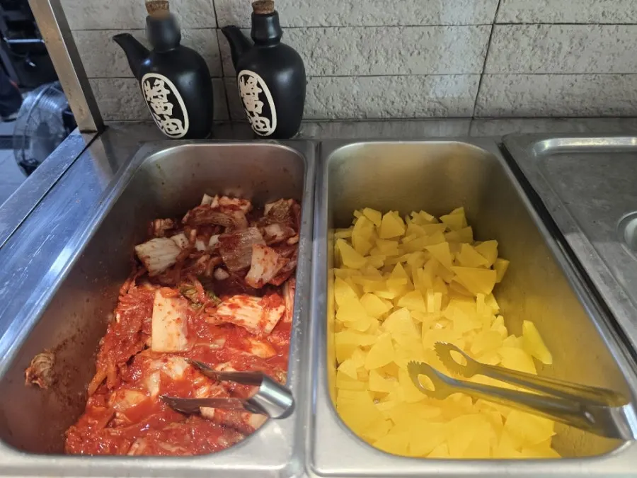 Basic side dishes of pickled radish and kimchi at the self-serve corner