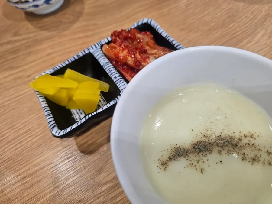 A bowl of soup brought back with pepper sprinkled on top