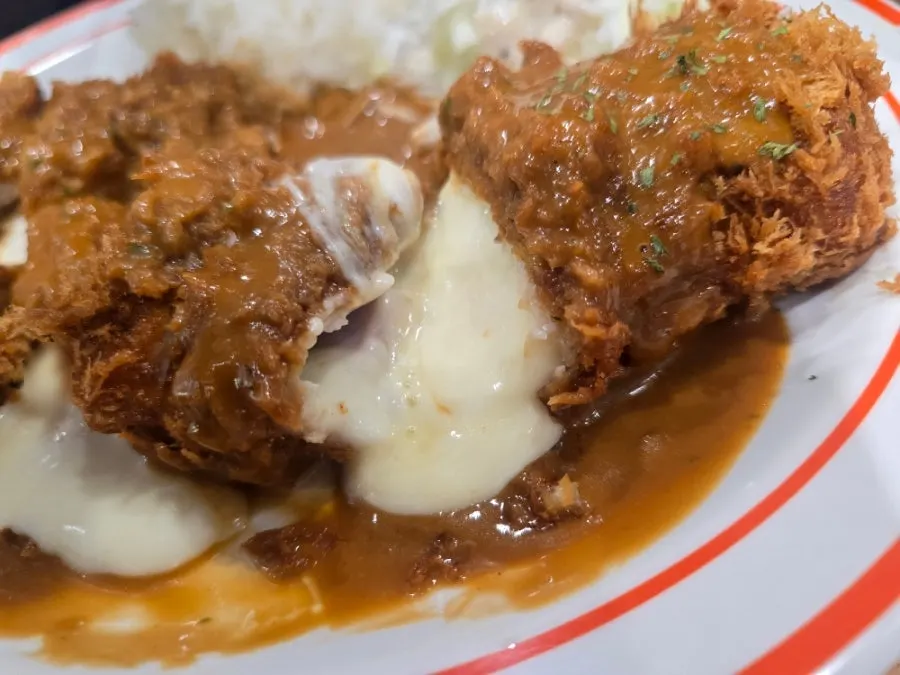 Cheese pork cutlet with cheese oozing out right after cutting