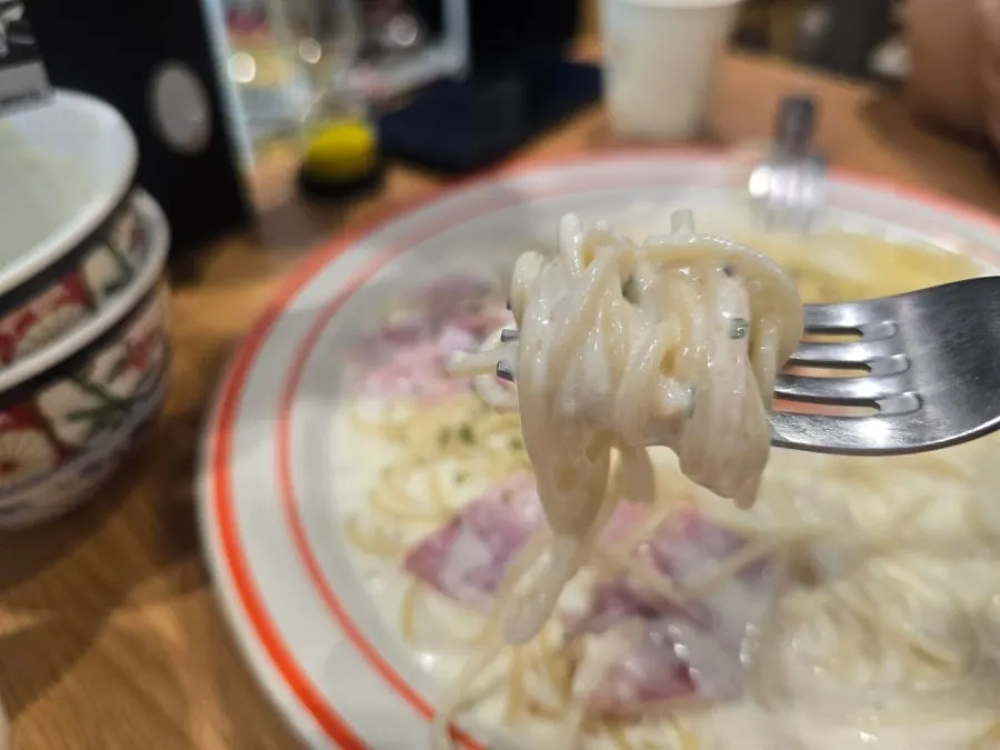 A forkful of pasta noodles coated in cream sauce