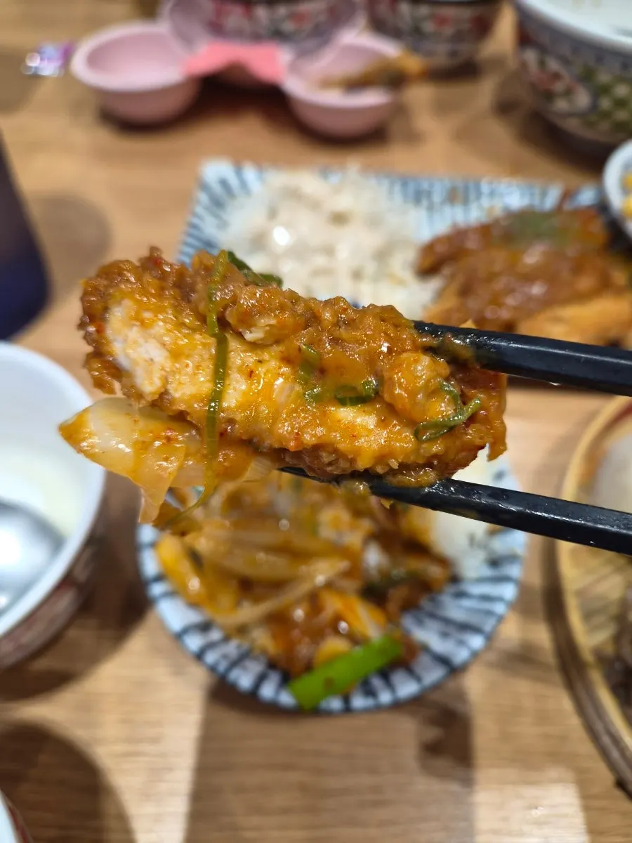 돈까스 한 조각에 매콤 양파를 올린 한입
