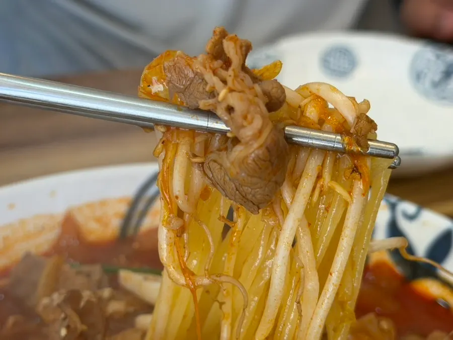 우삼겹과 면을 함께 집어 올린 모습