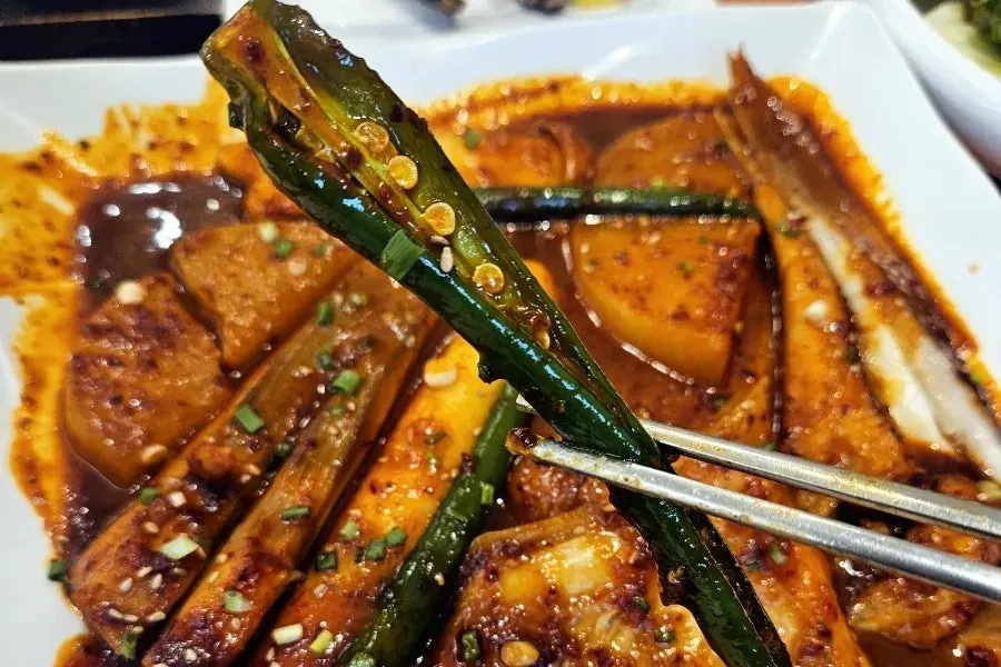 Mixing sauce-coated radish into a bowl of rice