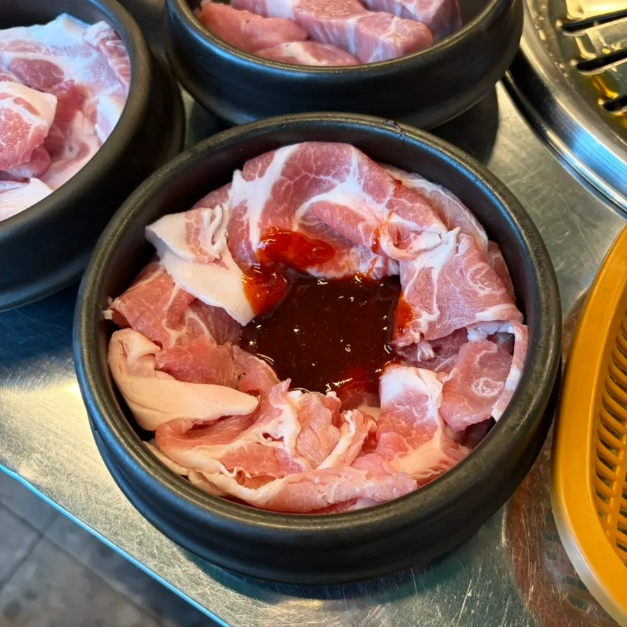 Thick slices of pork neck grilling on the pan