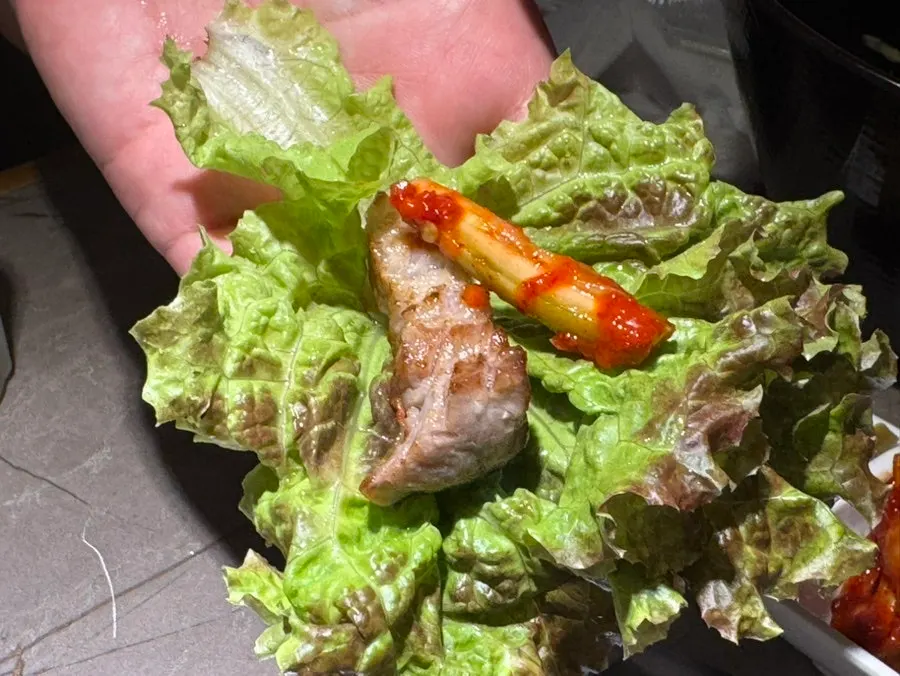 A piece of grilled pork belly with wrap vegetables