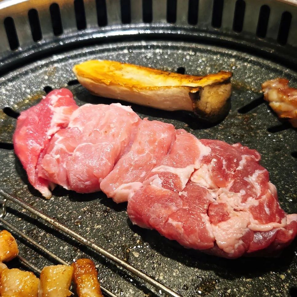 불판에서 익어가는 고기와 곁들임 반찬