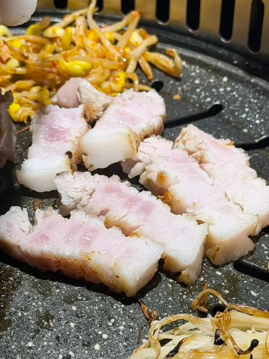 쌈채소에 올린 삼겹살 한 점