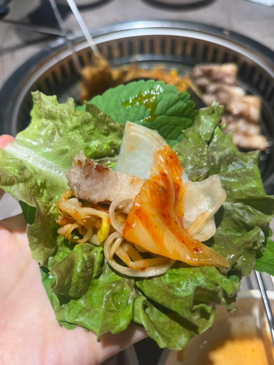 쌈에 삼겹살과 콩나물, 쌈장을 올린 모습