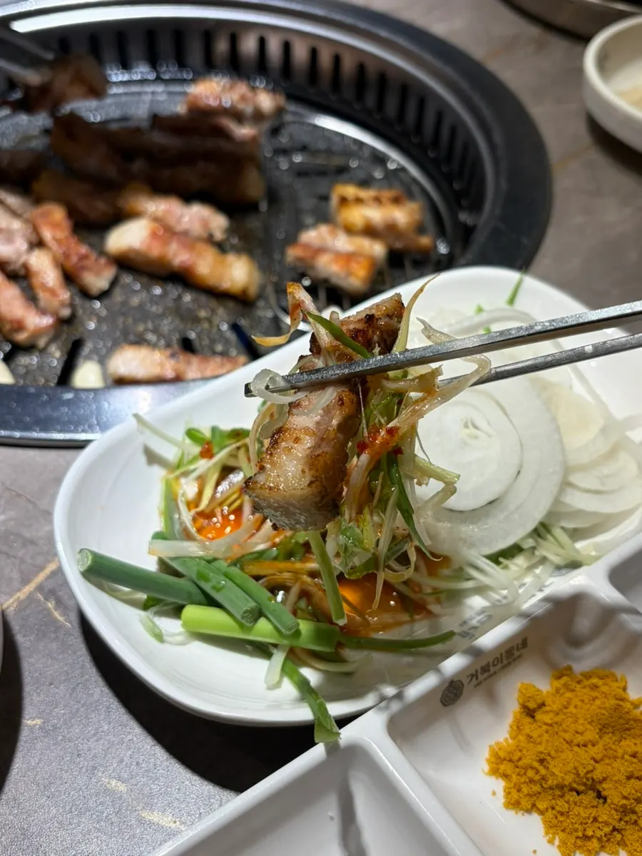 Whole garlic and white kimchi grilling on the hot plate