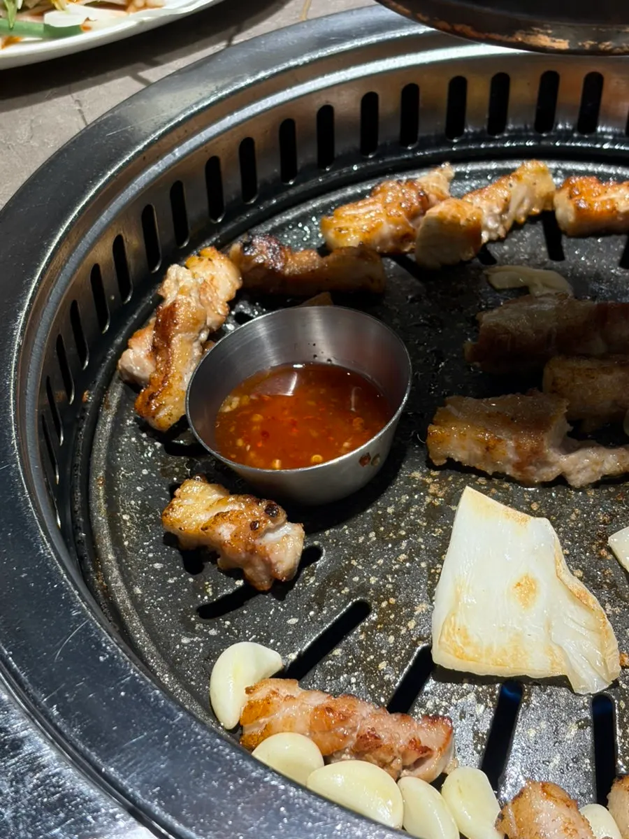 A piece of pork belly topped with pickled scallions