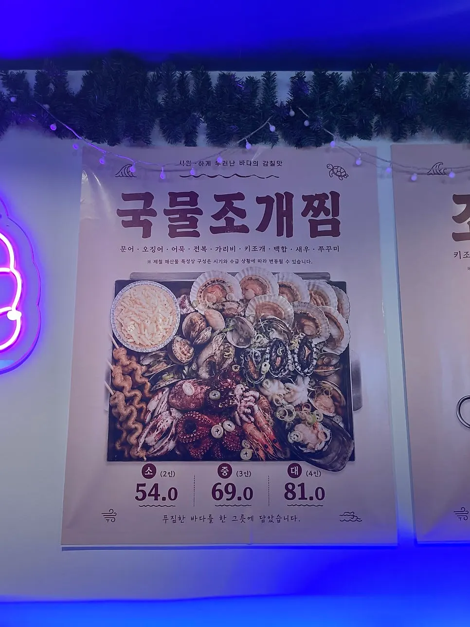 Menu board listing steamed and grilled clams