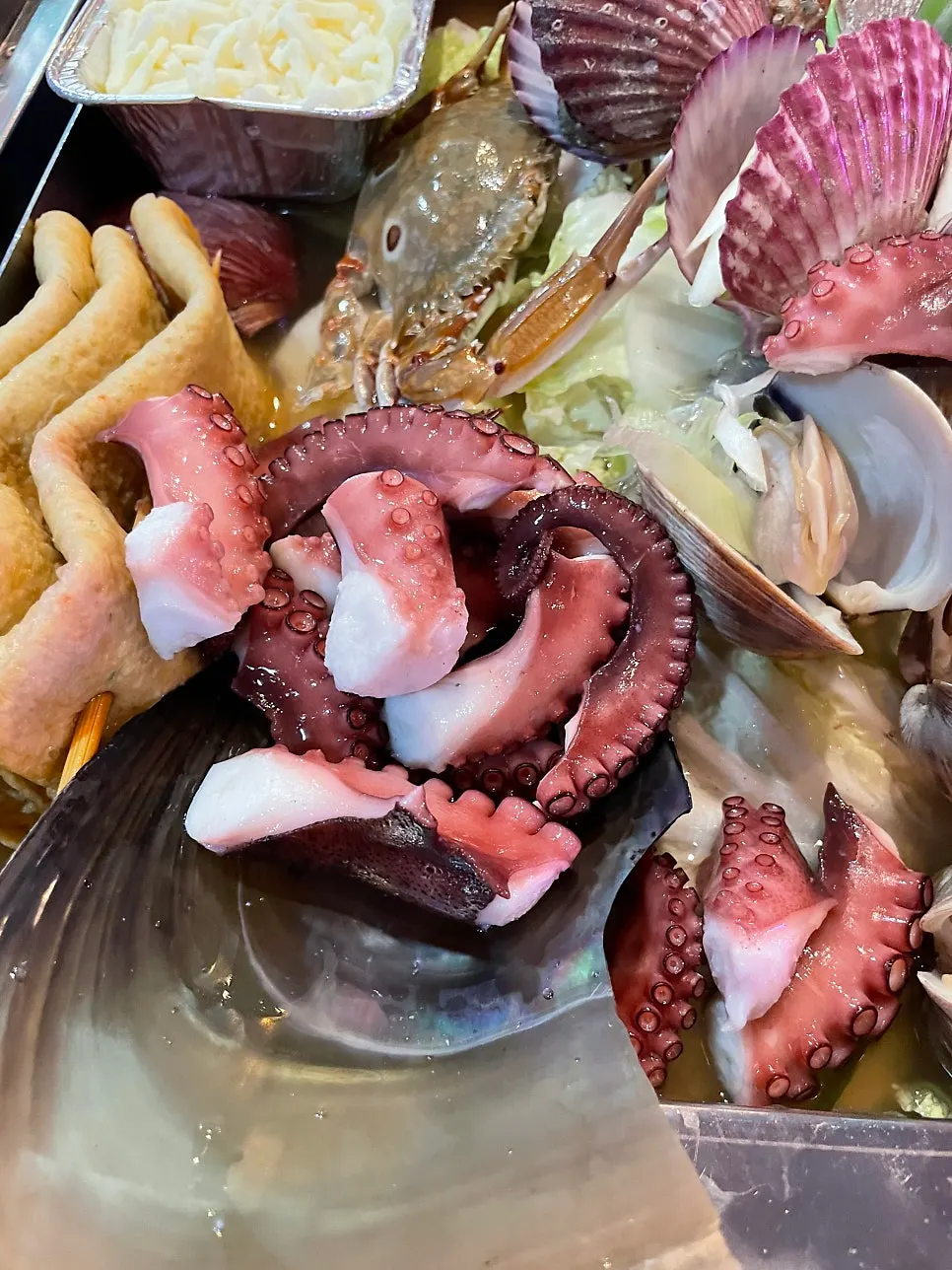 A glass of soju alongside the steamed clams