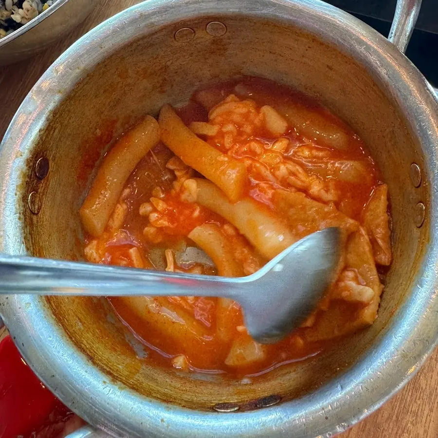 Rice balls and tteokbokki set beside the clam stew