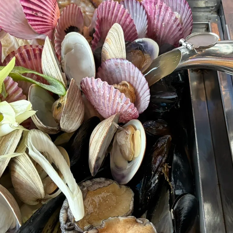 Secret broth being poured into the steamed clams