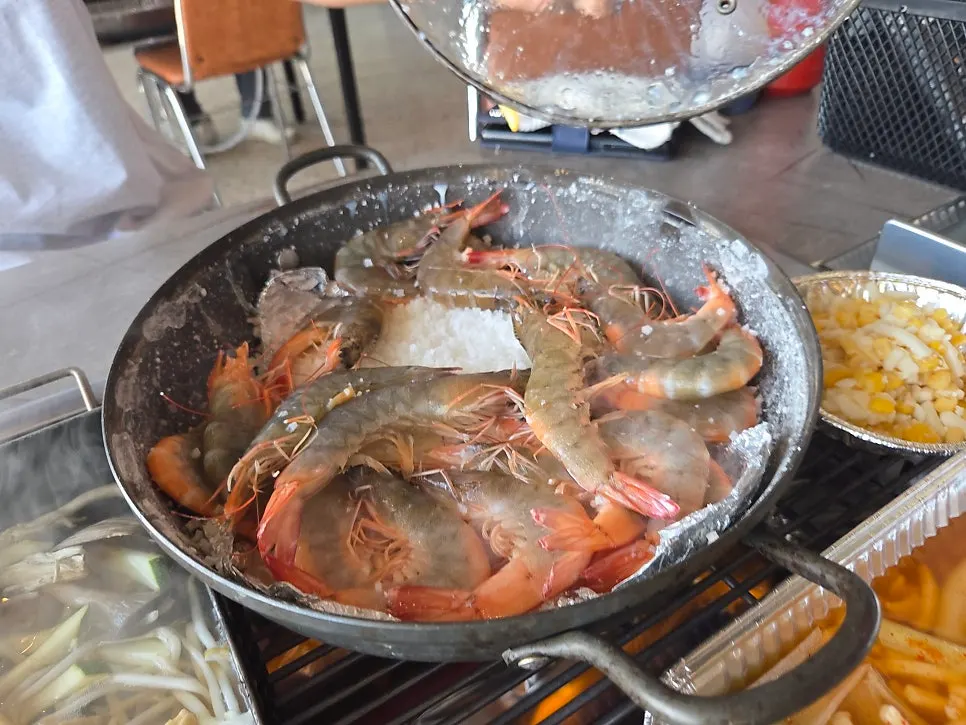 Grilled shrimp cooking over coarse salt