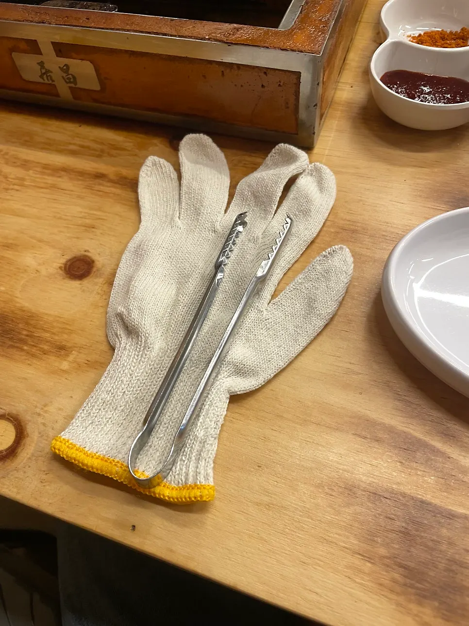 Disposable gloves and mini tongs hanging on the table