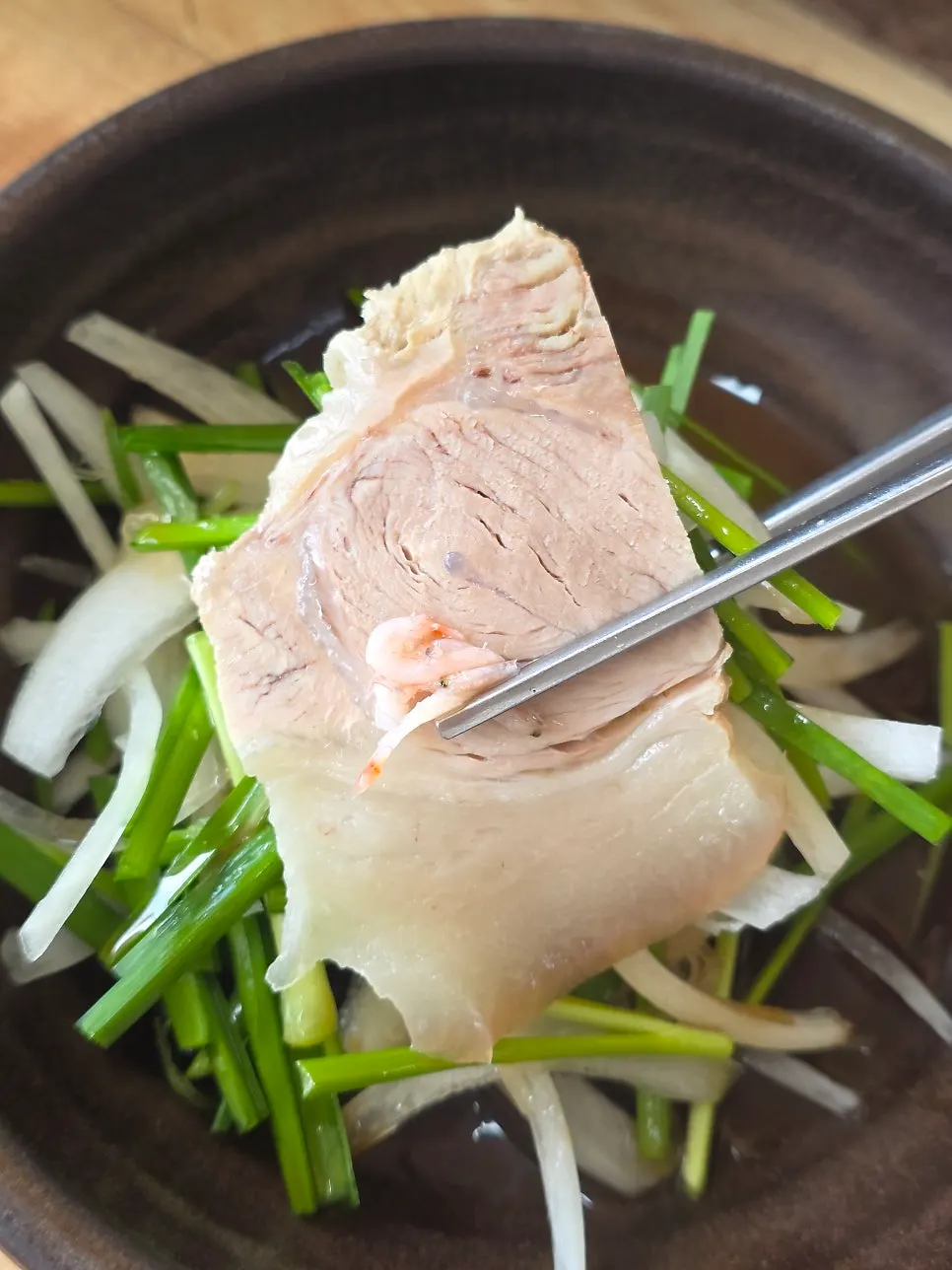 Stone pot of pork gukbap broth served alongside the suyuk
