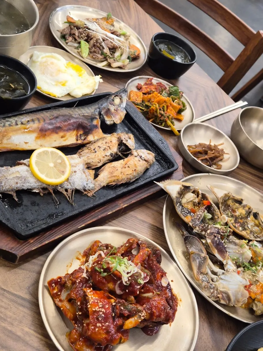 Full table spread of the grilled fish and flower crab set for two