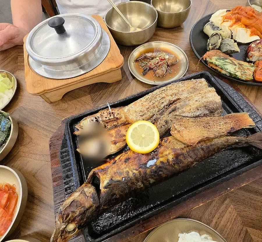 A table with golden grilled fish and hot pot rice