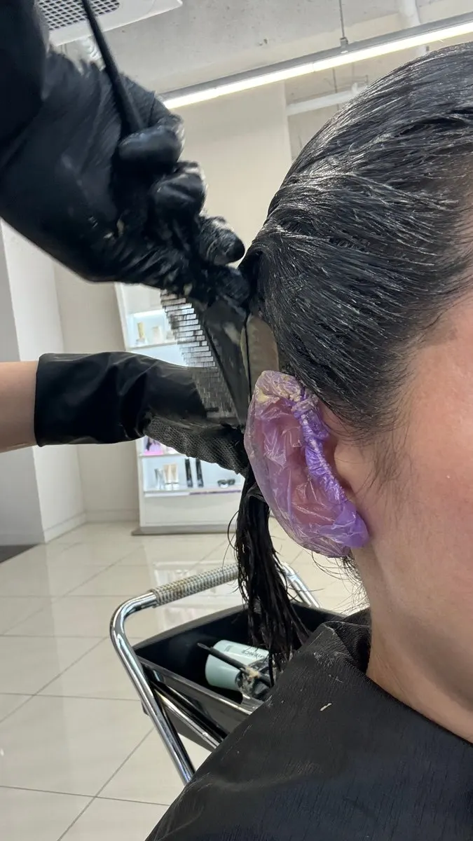 Stylist manager carefully applying the dye