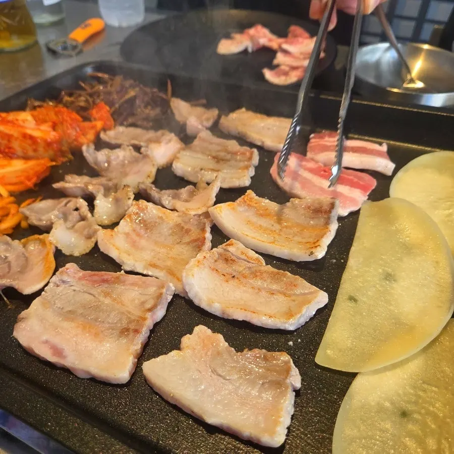 Samgyeopsal grilling with kimchi and gosari on the plate