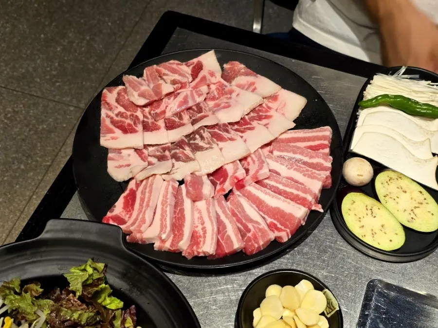 Table spread of basic side dishes and free menu items at Taedon