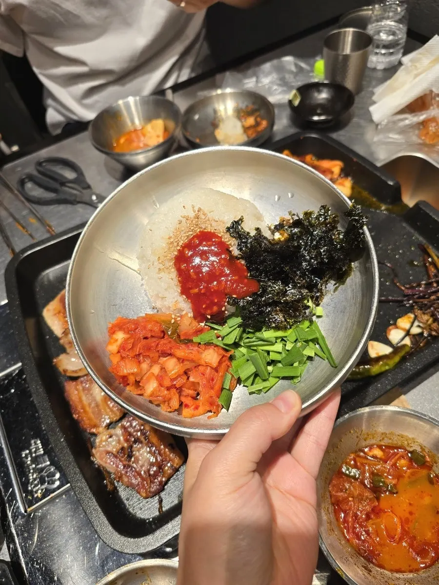 A piece of pork belly dipped in seasoned sauce