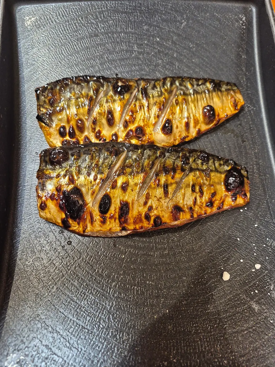Wood-fired grilled mackerel placed on the induction burner