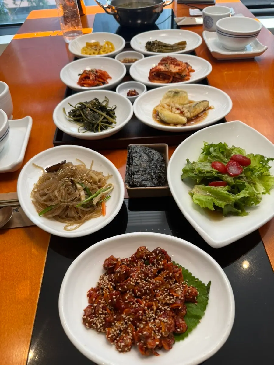 Table filled with pot rice and various banchan