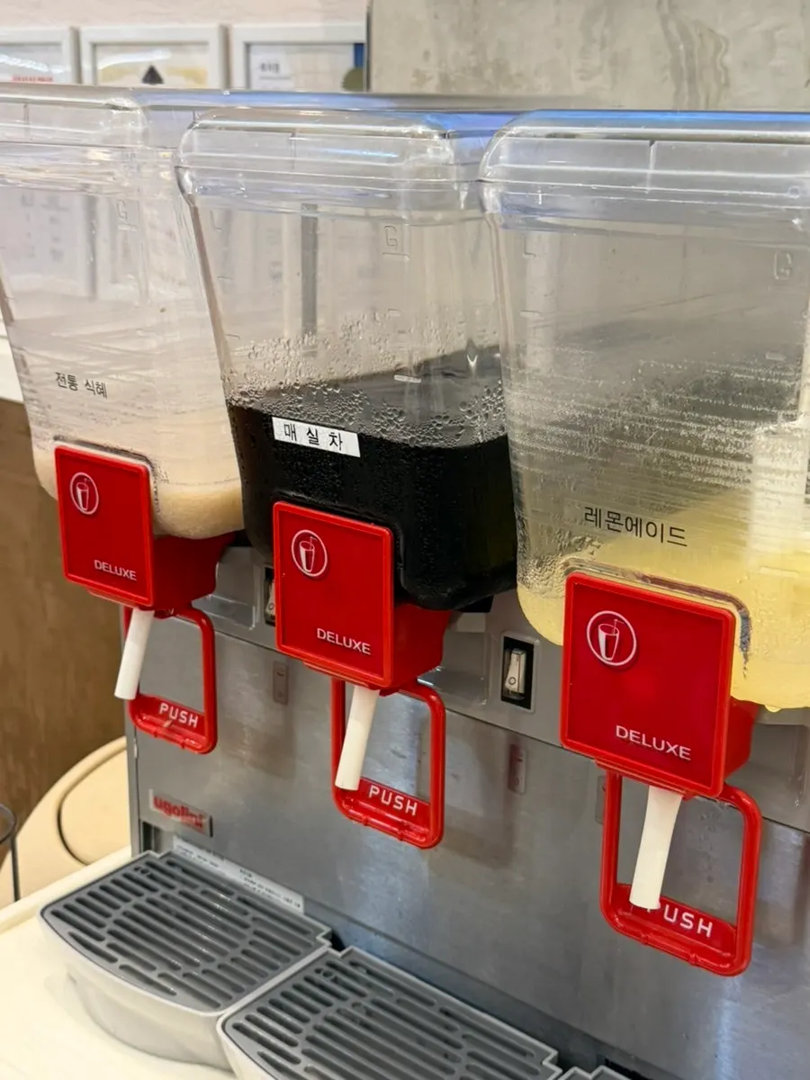 Self-serve drink station with paper cups and ice cups