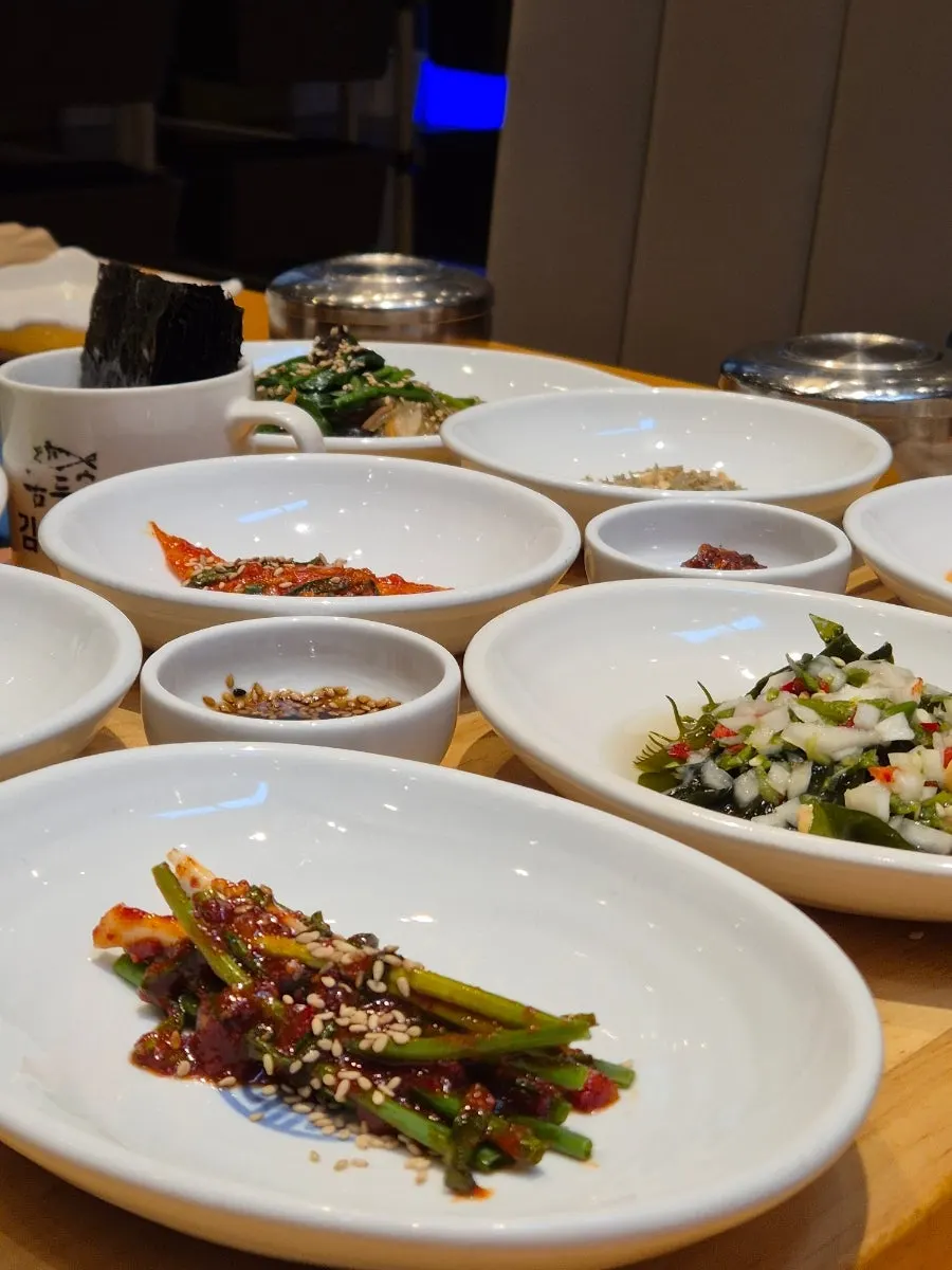 Bowls of green onion kimchi and young radish kimchi