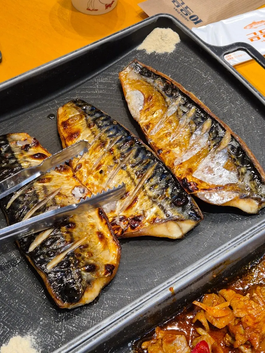 Table with both stir-fried pork and grilled mackerel