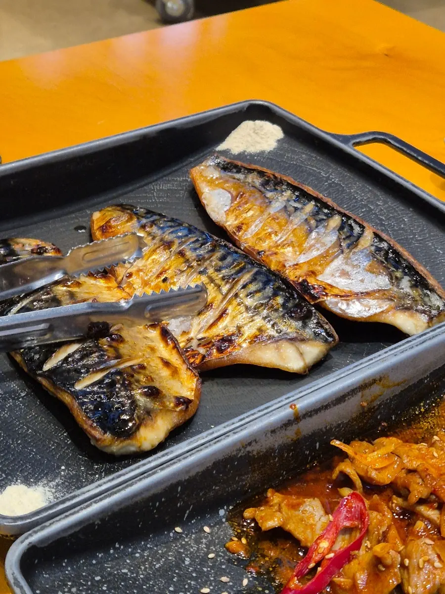 A piece of grilled mackerel with crispy skin and moist flesh