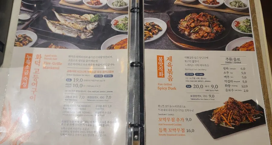 Menu board listing wood-fired grilled mackerel and spicy pork stir-fry