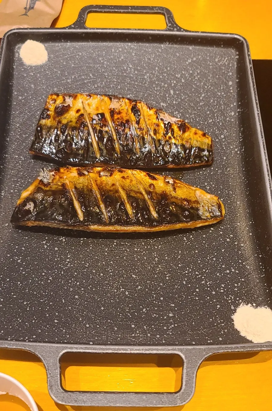 Golden-brown wood-fired grilled mackerel served whole