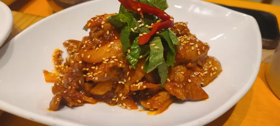 A plate of spicy pork stir-fry with a hint of perilla leaf