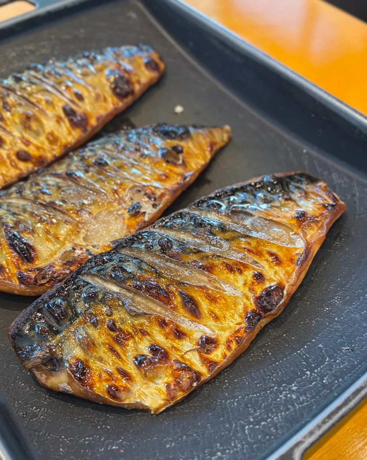 Nuruk salt-cured wood-fired grilled mackerel served on an iron plate
