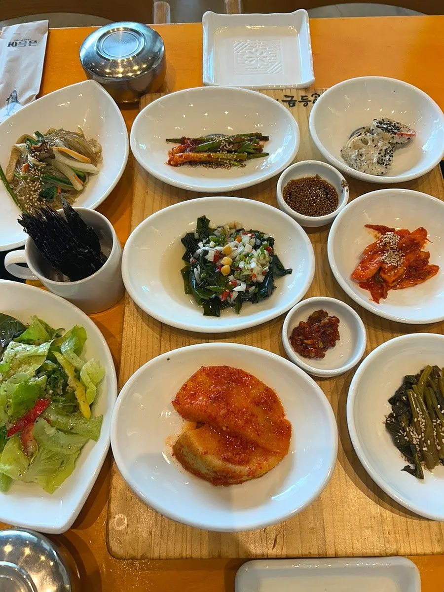 Seasonal side dishes including green onion kimchi and seaweed salad
