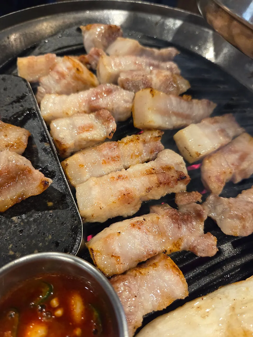 Staff grilling pork belly with fernbrake on the side
