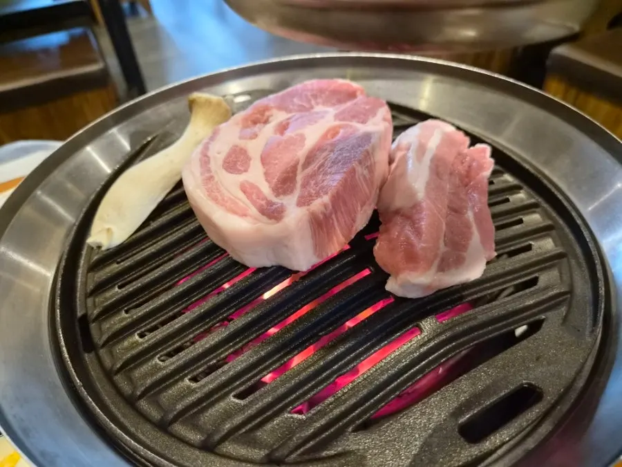 직원이 화로에서 고기를 굽는 장면