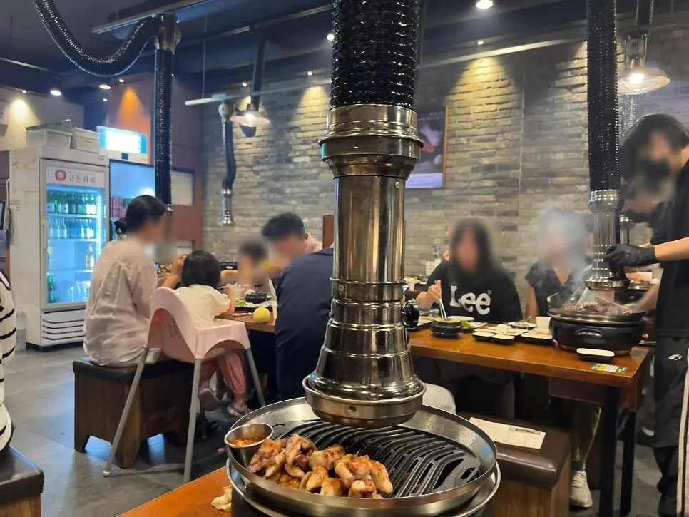 Staff grilling meat at a Geumdon Hwaro table