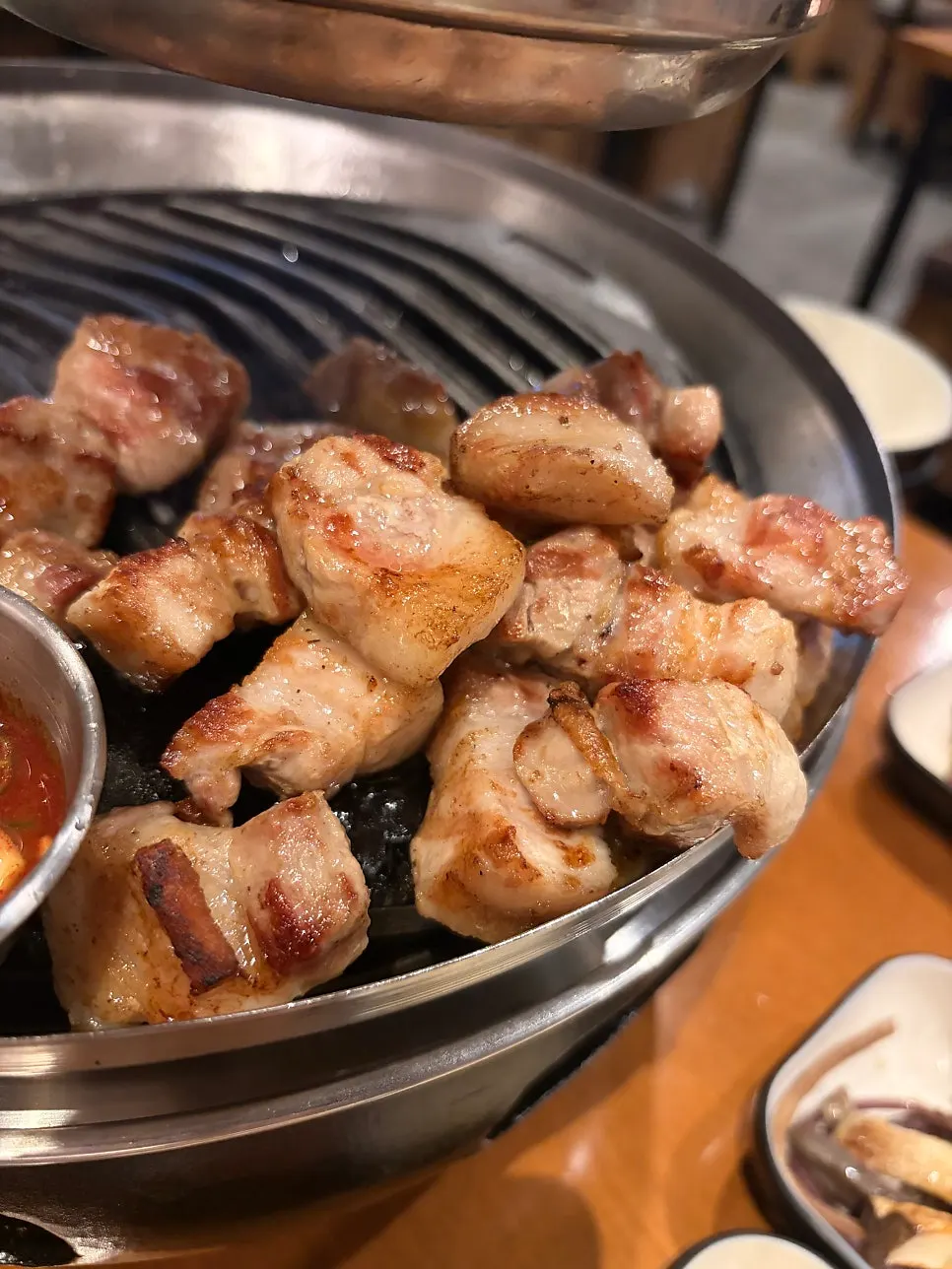 Thick pork belly grilling over the charcoal brazier