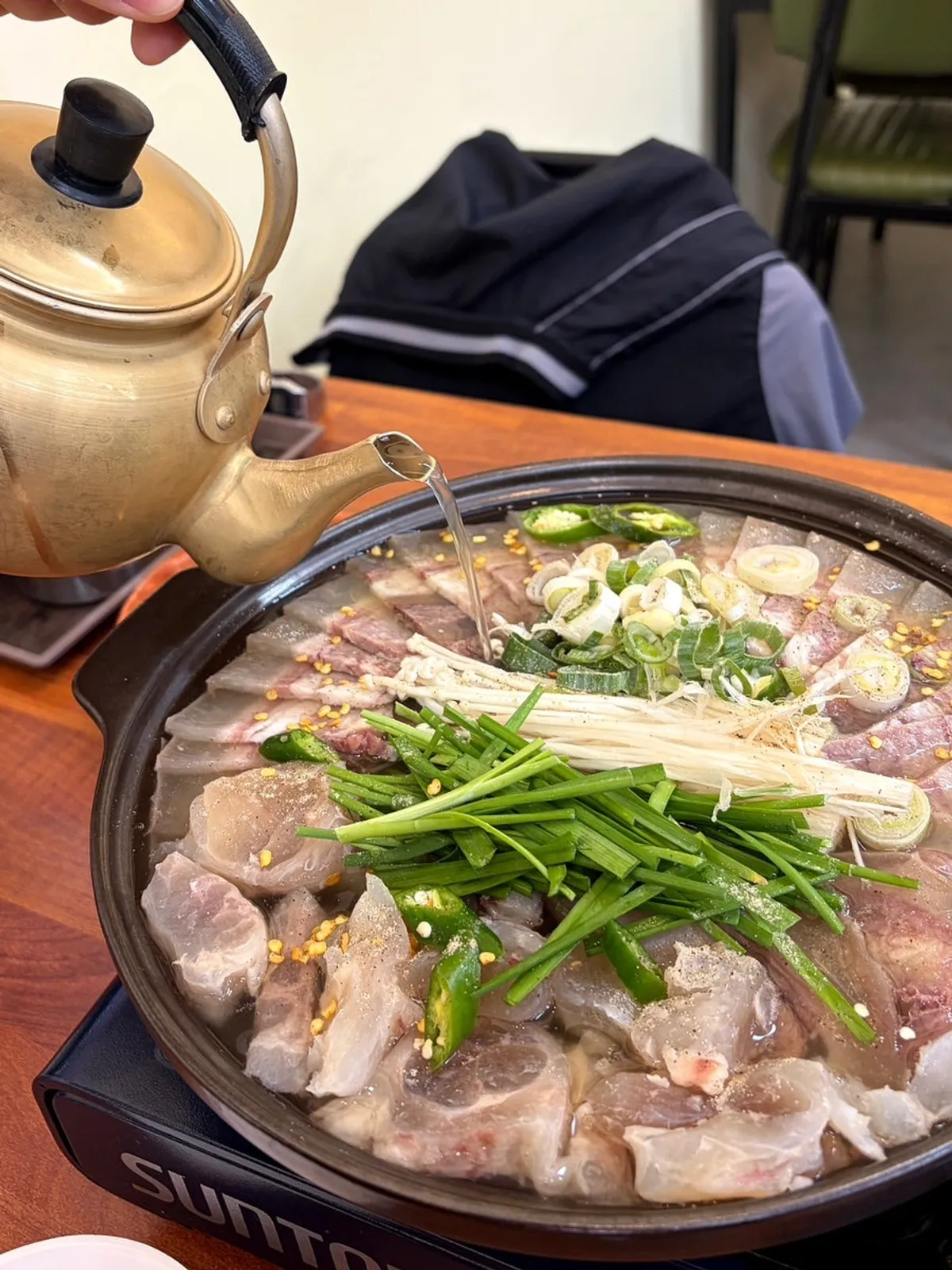 Broth being poured and simmered into the beef boiled meat hot pot